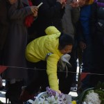 Photographer: Greg Baker/AFP via Getty Images A woman places flowers near the site of a New Year's Eve stampede at the Bund in Shanghai on January 1, 2015.